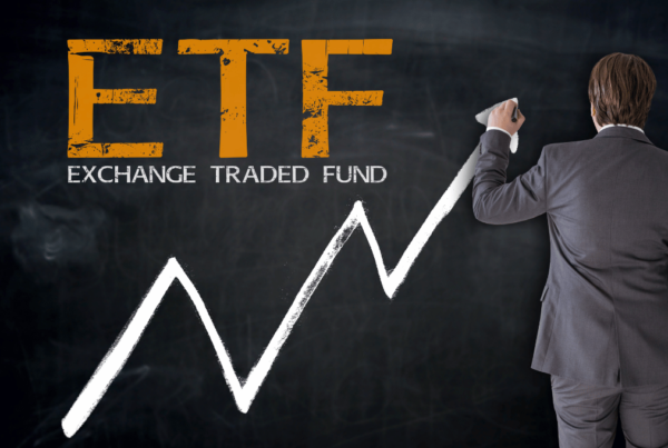 A man writing ETF with an ascending arrow on a blackboard