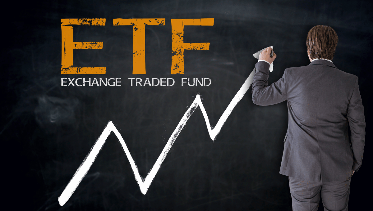 A man writing ETF with an ascending arrow on a blackboard