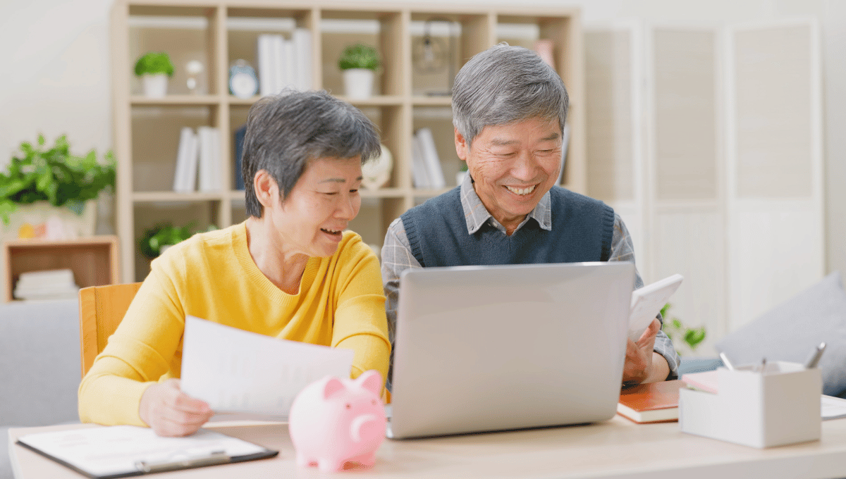elderly couple looking at their laptop and mobile phone