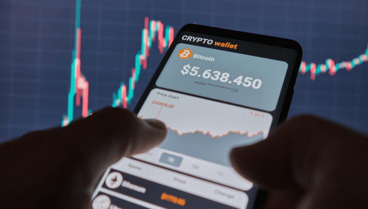 Two hands holding a phone with a crypto wallet app open.